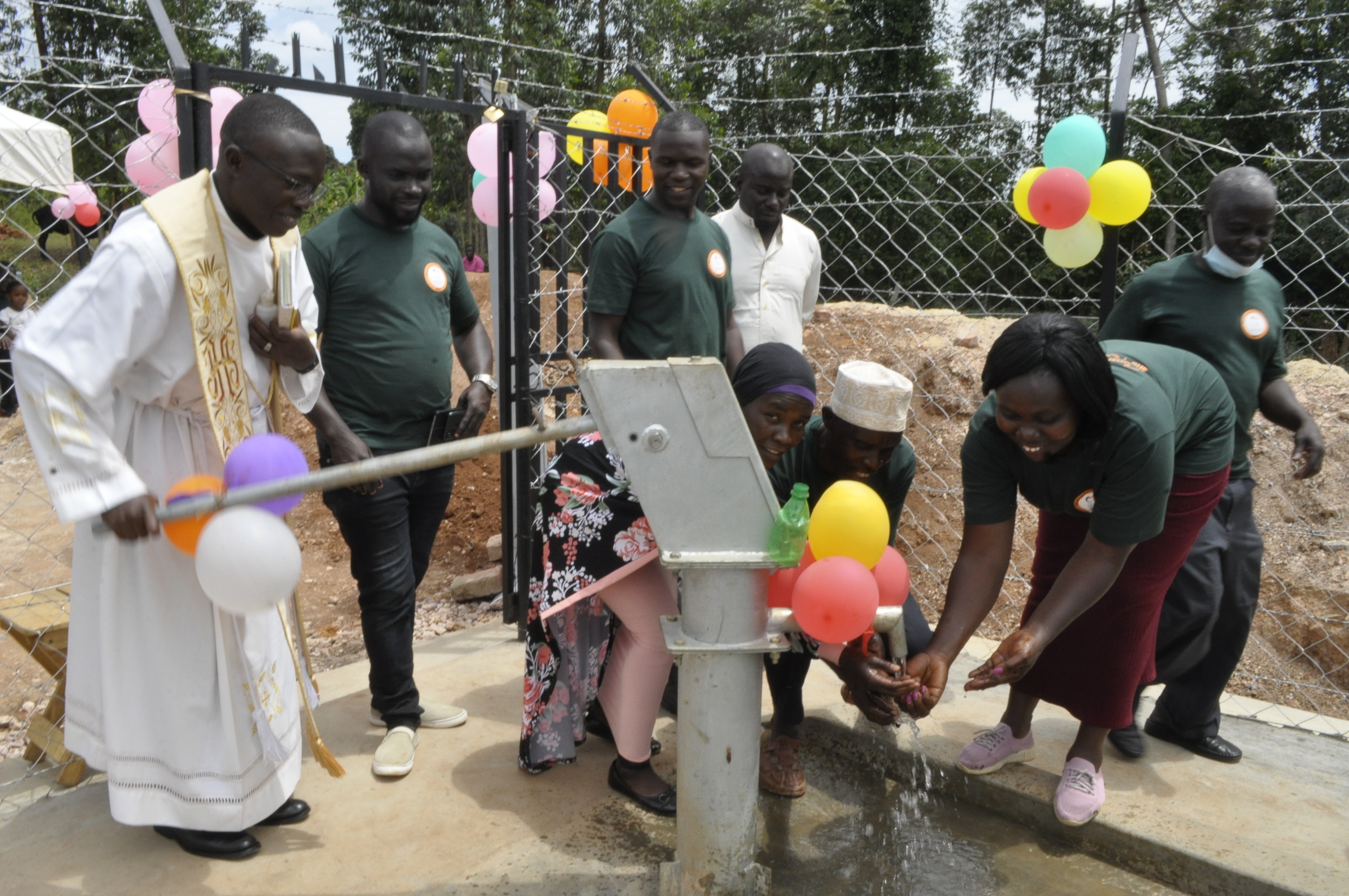 Community celebrating borehole launch with balloons in Butaaya